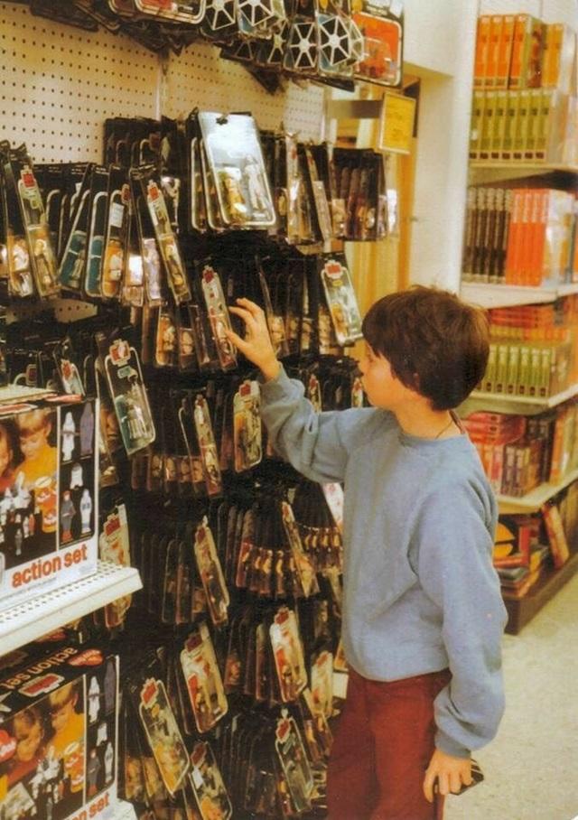 1980s store front, with a boy reaching for a Kenner Star Wars action figure